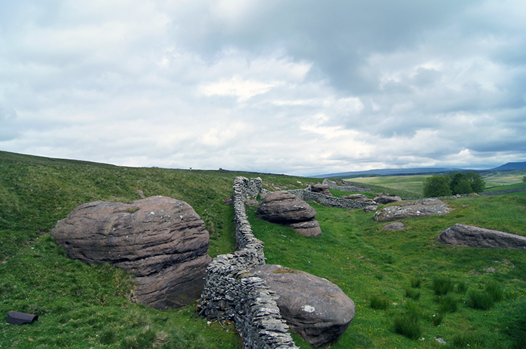 The wall curves around rocks