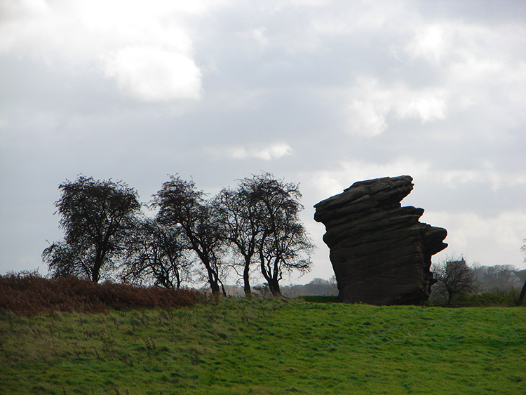 A silhouetted gritstone figure shows its face