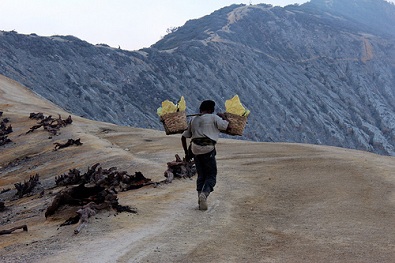 Sulphur miner atop Kawah Ijen maing a living in the hardest possible conditions